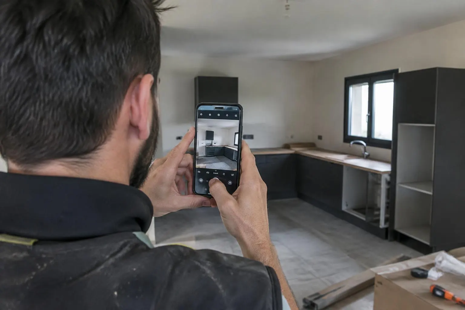 Artisan prenant une photo de son chantier avec son téléphone